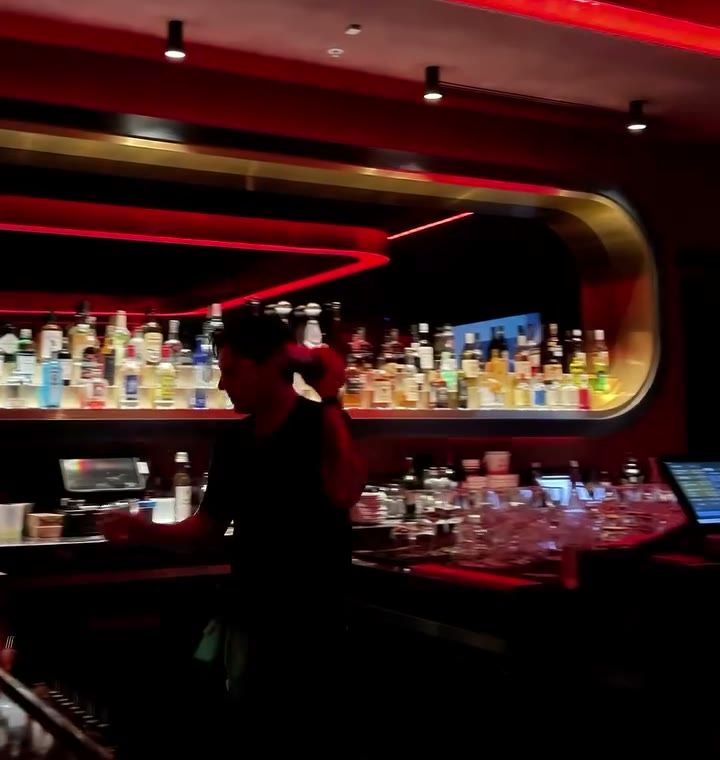 The full back bar glowing under the brass canopy