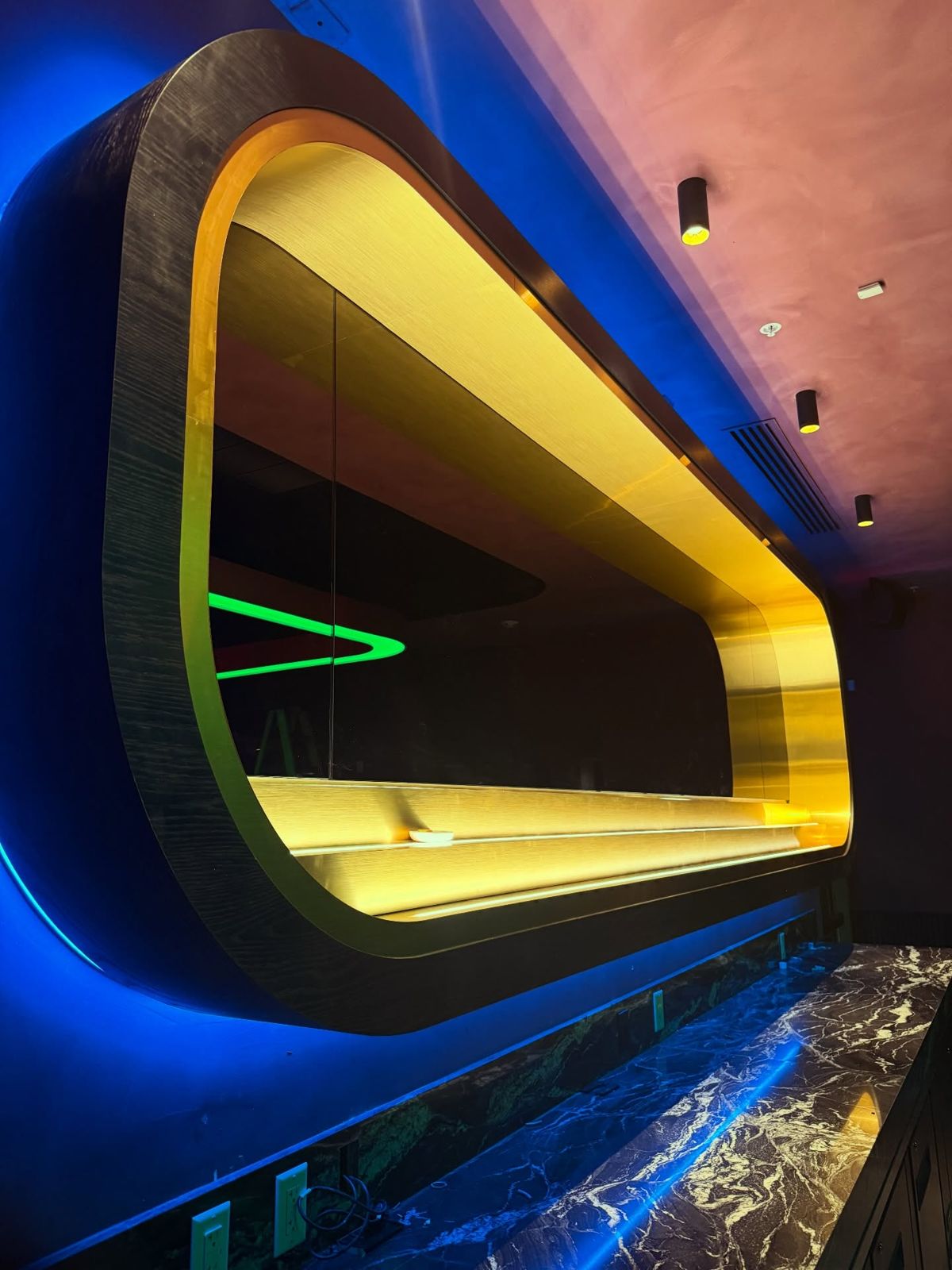 Brass bar canopy lit yellow and blue