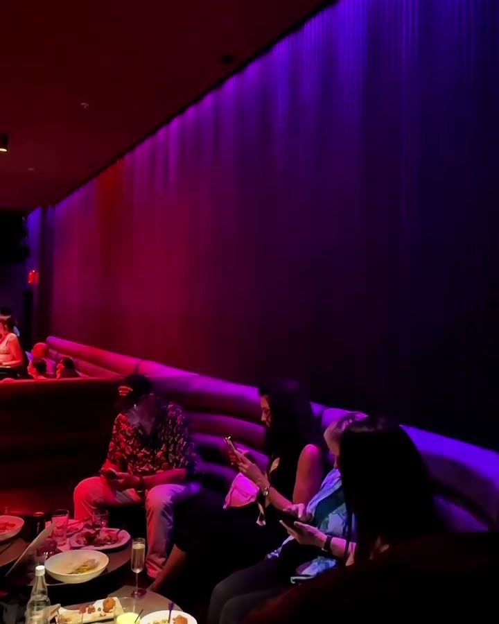 Banquette seating beside the dance floor in low red light